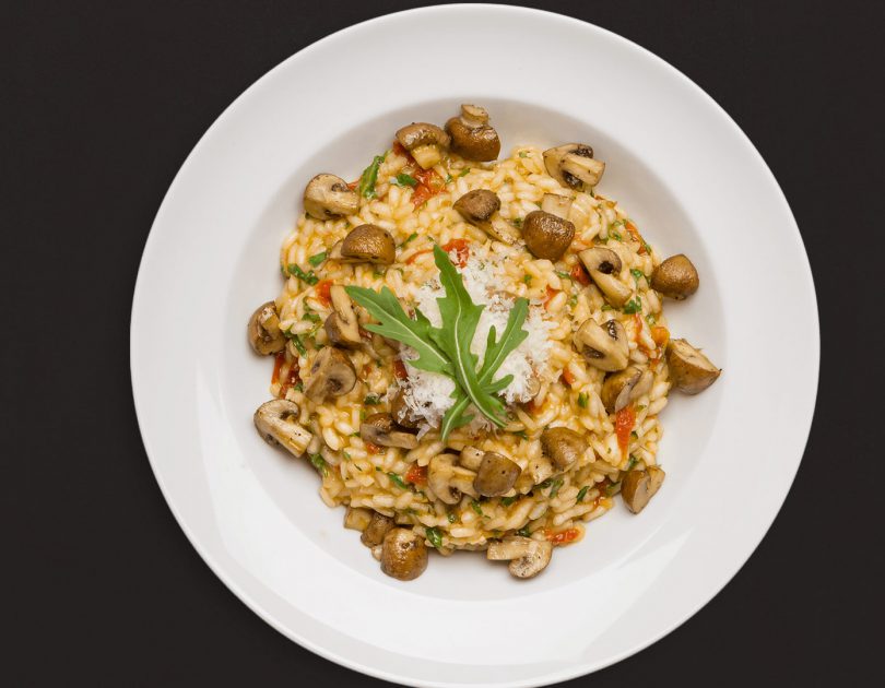 Tomaten-Rucola-Risotto und gebackenen Champignons